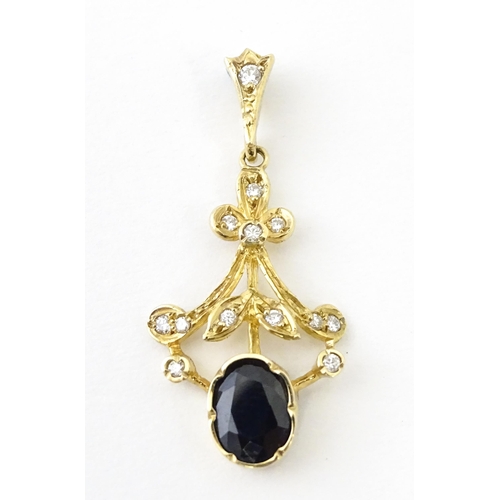 655 - A 9ct gold pendant set with diamonds and dark stone. Approx. 1 1/2