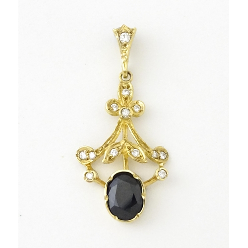 655 - A 9ct gold pendant set with diamonds and dark stone. Approx. 1 1/2