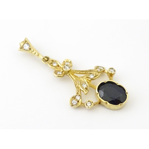 655 - A 9ct gold pendant set with diamonds and dark stone. Approx. 1 1/2