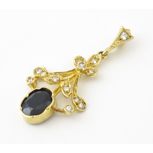 655 - A 9ct gold pendant set with diamonds and dark stone. Approx. 1 1/2