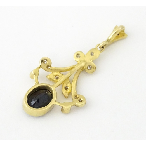 655 - A 9ct gold pendant set with diamonds and dark stone. Approx. 1 1/2