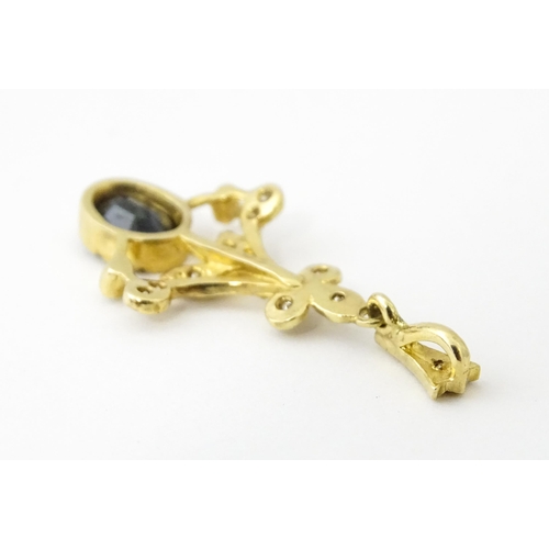 655 - A 9ct gold pendant set with diamonds and dark stone. Approx. 1 1/2