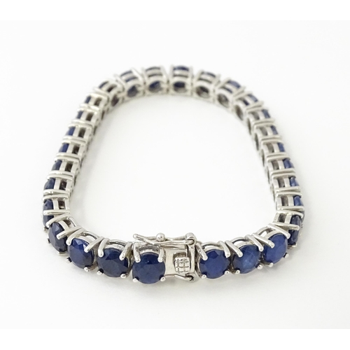 657 - A silver bracelet set with sapphire coloured blue stones. Approx. 7