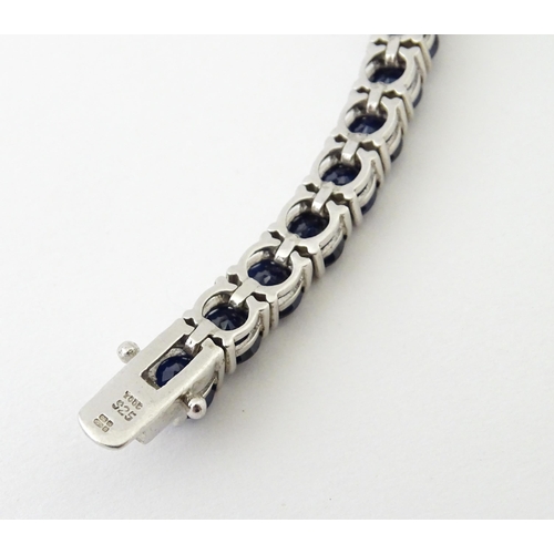 657 - A silver bracelet set with sapphire coloured blue stones. Approx. 7