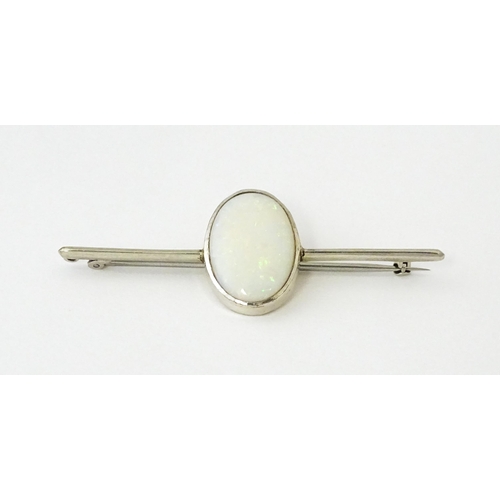 662 - A 9ct white gold bar brooch set with central oval opal cabochon. The opal approx. 3/4