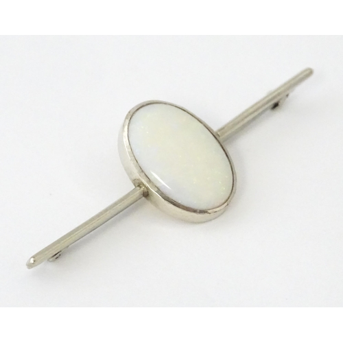 662 - A 9ct white gold bar brooch set with central oval opal cabochon. The opal approx. 3/4