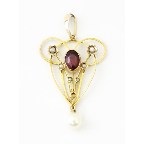 664 - A 9ct gold pendant in the Art Nouveau style set with central garnet flanked by seed pearls with pear... 