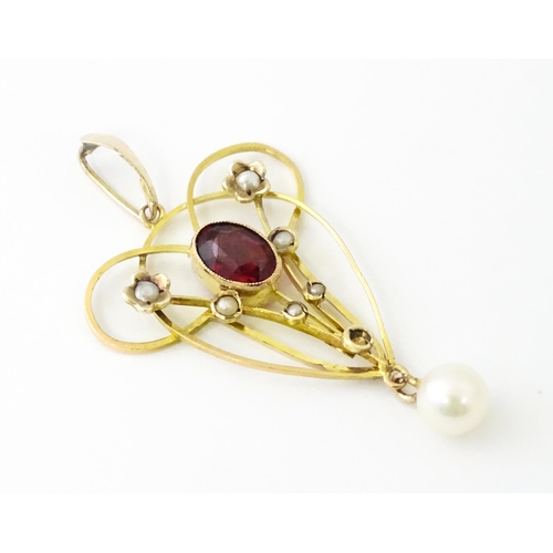 664 - A 9ct gold pendant in the Art Nouveau style set with central garnet flanked by seed pearls with pear... 