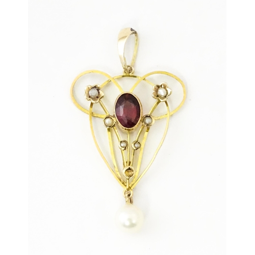 664 - A 9ct gold pendant in the Art Nouveau style set with central garnet flanked by seed pearls with pear... 