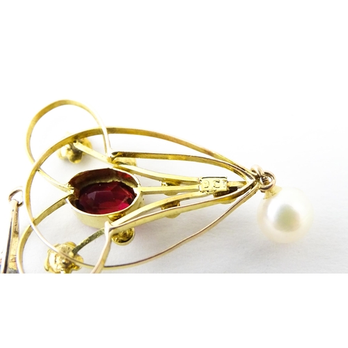 664 - A 9ct gold pendant in the Art Nouveau style set with central garnet flanked by seed pearls with pear... 