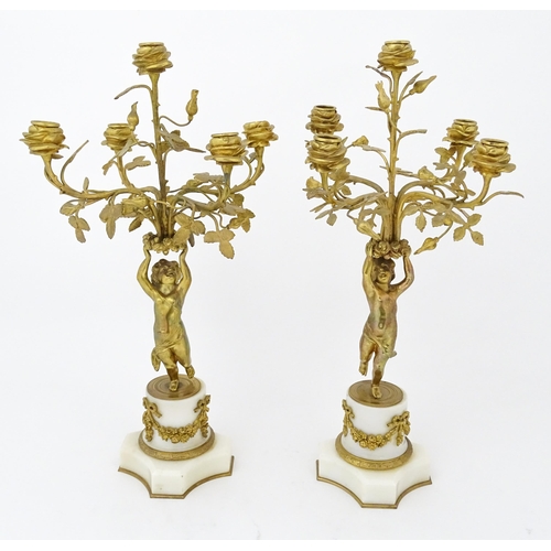 1396 - A late 19thC French white marble ormolu clock garniture, the clock formed as three ormolu putti hold... 