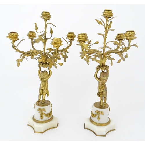 1396 - A late 19thC French white marble ormolu clock garniture, the clock formed as three ormolu putti hold... 