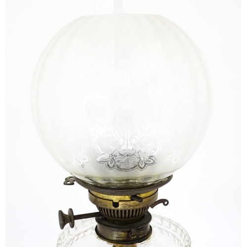 1421 - A Victorian oil lamp, the adjustable height cast base with clear glass reservoir with etched shade w... 