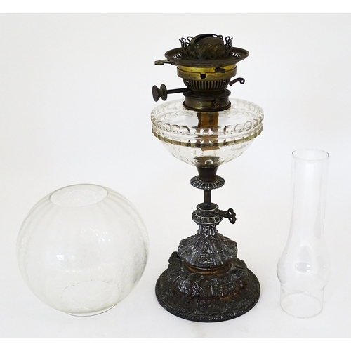 1421 - A Victorian oil lamp, the adjustable height cast base with clear glass reservoir with etched shade w... 