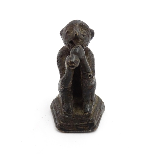 1010 - An Oriental cast model of a seated monkey, possibly a scroll weight. Together with a 20thC brass mat... 