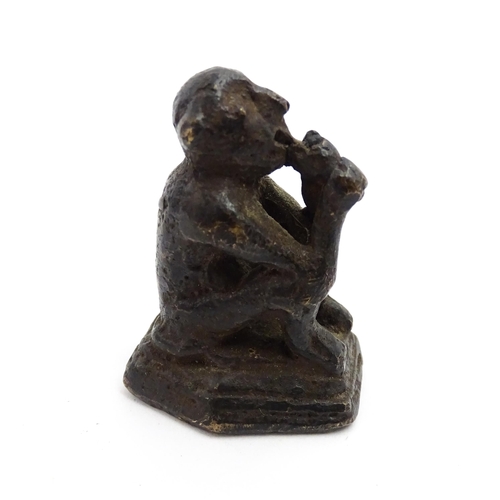 1010 - An Oriental cast model of a seated monkey, possibly a scroll weight. Together with a 20thC brass mat... 