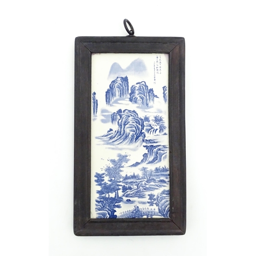 1027 - A Chinese blue and white transferware tile depicting a landscape scene with figures. Character marks... 