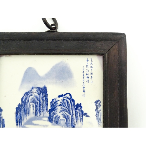 1027 - A Chinese blue and white transferware tile depicting a landscape scene with figures. Character marks... 