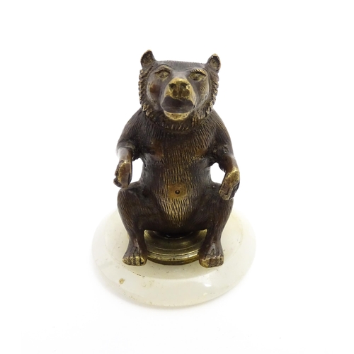 1051 - A 20thC gilt metal model of a seated bear. Approx. 2 3/4