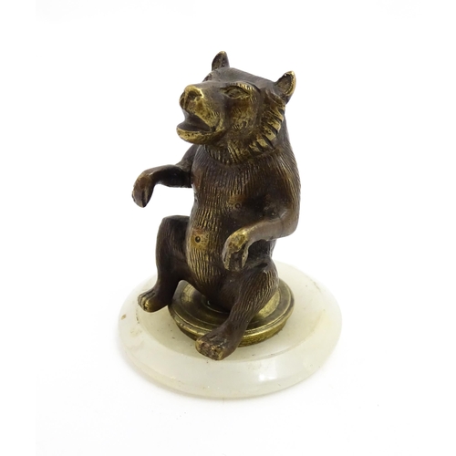 1051 - A 20thC gilt metal model of a seated bear. Approx. 2 3/4