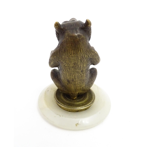 1051 - A 20thC gilt metal model of a seated bear. Approx. 2 3/4