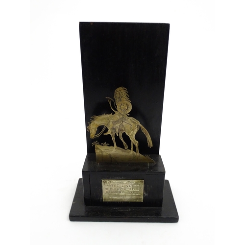 1085 - An early 20thC trophy depicting a Native American Indian on horseback on an ebonised base, bearing a... 