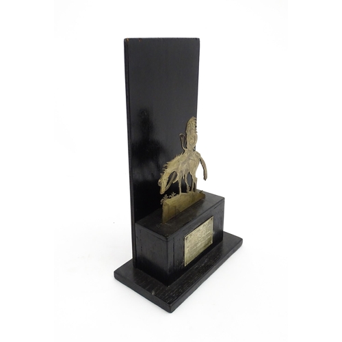 1085 - An early 20thC trophy depicting a Native American Indian on horseback on an ebonised base, bearing a... 