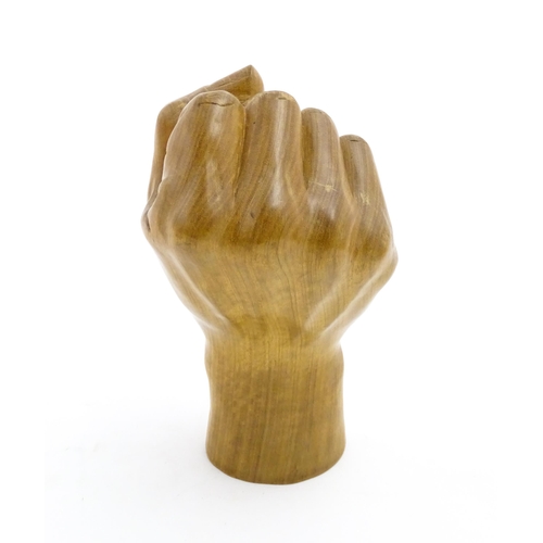 1135 - A late 20thC carved wooden model of a hand in a fist. Signed under Solomon. Approx. 6 1/2