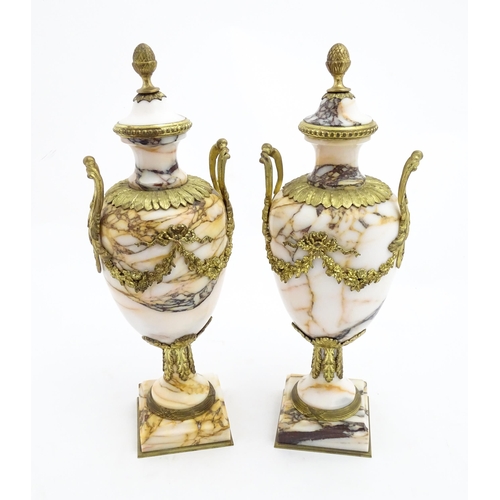 1223 - A pair of marble urns of pedestal form with gilt metal swag and bow mounts, twin handles and acanthu... 