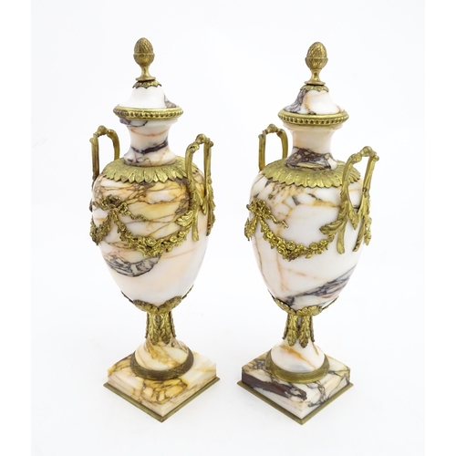 1223 - A pair of marble urns of pedestal form with gilt metal swag and bow mounts, twin handles and acanthu... 