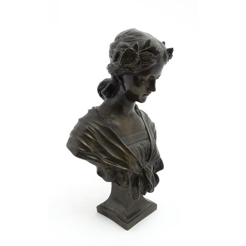 1226 - A 20thC cast bust of a young woman with flowers in her hair. Approx. 17 1/4