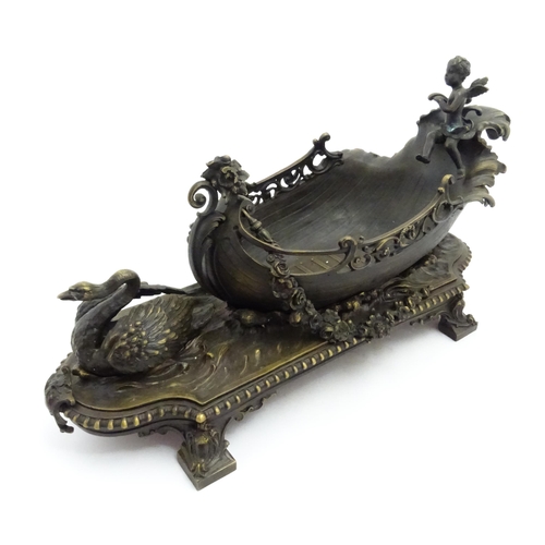 1227 - A late 20thC cast centrepiece formed as a boat with a cherub / putto at the helm preceded by a swan.... 