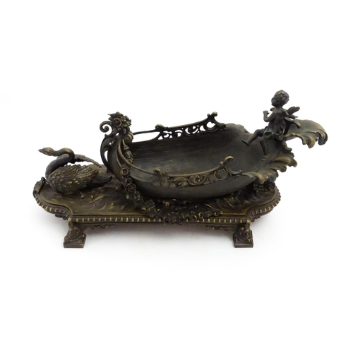 1227 - A late 20thC cast centrepiece formed as a boat with a cherub / putto at the helm preceded by a swan.... 