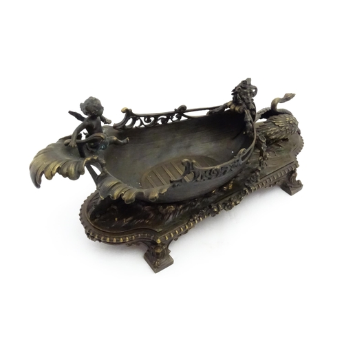 1227 - A late 20thC cast centrepiece formed as a boat with a cherub / putto at the helm preceded by a swan.... 