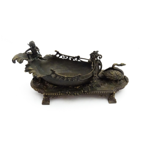 1227 - A late 20thC cast centrepiece formed as a boat with a cherub / putto at the helm preceded by a swan.... 