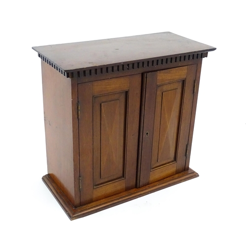 1238 - An early 20thC mahogany table top medicine cabinet with a dentil moulded frieze above two panelled c... 