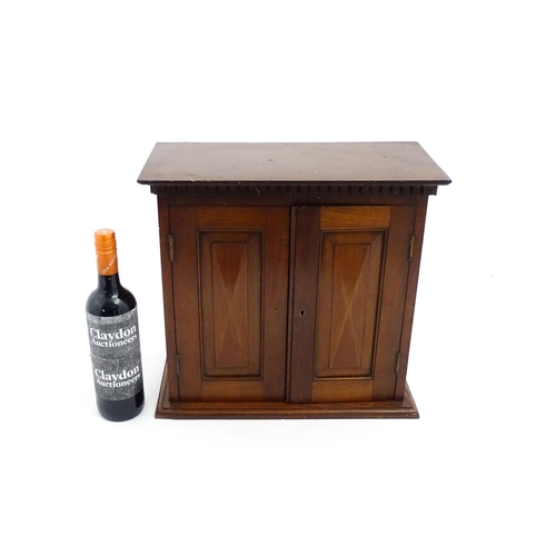 1238 - An early 20thC mahogany table top medicine cabinet with a dentil moulded frieze above two panelled c... 