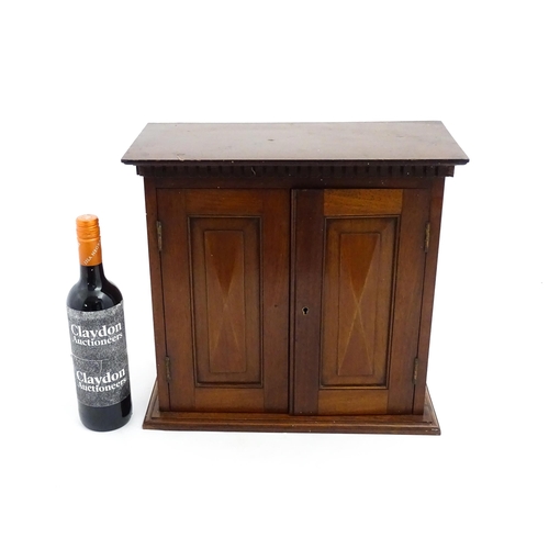 1238 - An early 20thC mahogany table top medicine cabinet with a dentil moulded frieze above two panelled c... 