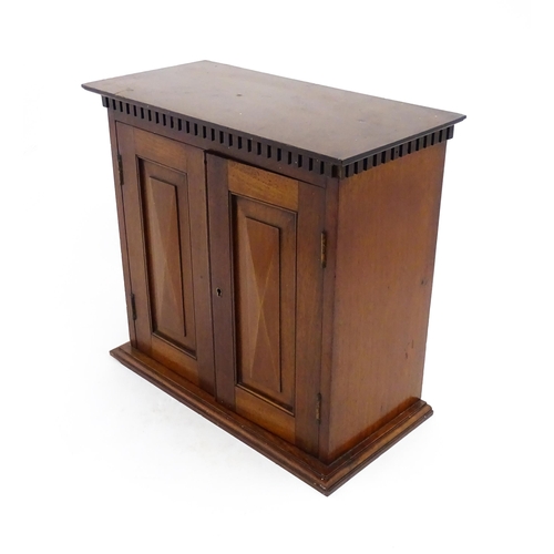 1238 - An early 20thC mahogany table top medicine cabinet with a dentil moulded frieze above two panelled c... 