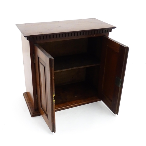 1238 - An early 20thC mahogany table top medicine cabinet with a dentil moulded frieze above two panelled c... 