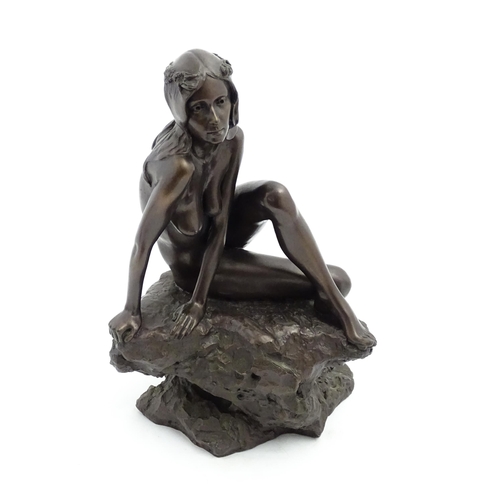 1242 - A 20thC bronzed resin sculpture after Brian Elton depicting a seated female nude on a rock. Bears ca... 