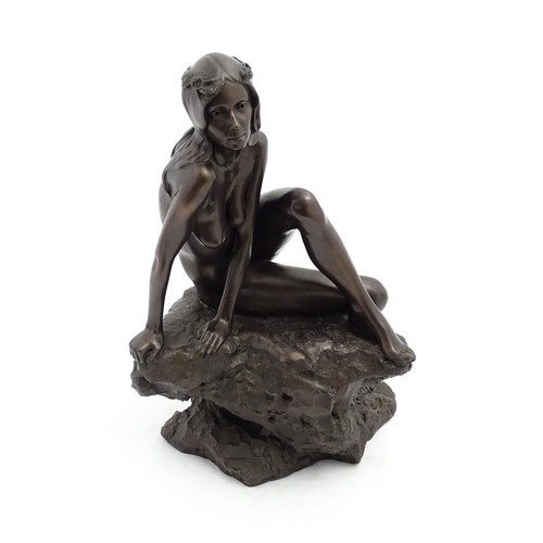 1242 - A 20thC bronzed resin sculpture after Brian Elton depicting a seated female nude on a rock. Bears ca... 