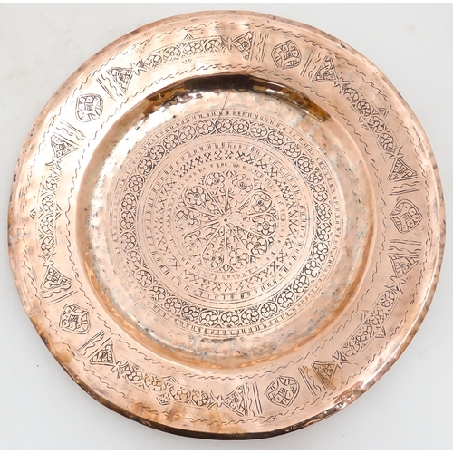 1250 - An Indian copper charger decorated with central floral motif and bordered by bands of flowers. Appro... 