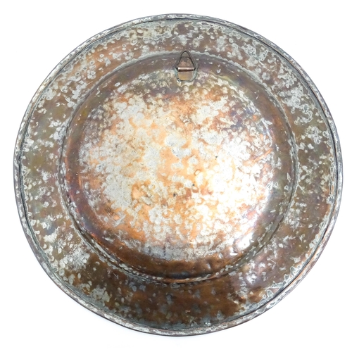 1250 - An Indian copper charger decorated with central floral motif and bordered by bands of flowers. Appro... 