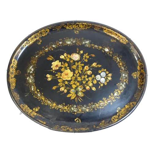 1251 - A Victorian papier mache tray of oval form decorated with gilt floral decoration and inlaid abalone ... 