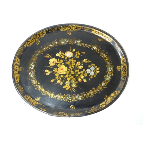 1251 - A Victorian papier mache tray of oval form decorated with gilt floral decoration and inlaid abalone ... 