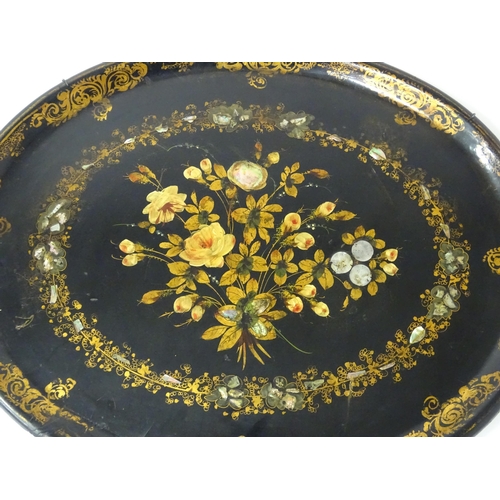 1251 - A Victorian papier mache tray of oval form decorated with gilt floral decoration and inlaid abalone ... 