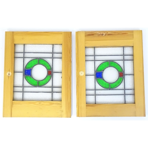 1261 - A pair of 20thC stained glass panels with green, red and blue roundel detail. Approx. 23 3/4