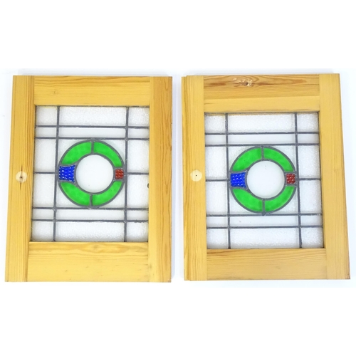 1261 - A pair of 20thC stained glass panels with green, red and blue roundel detail. Approx. 23 3/4