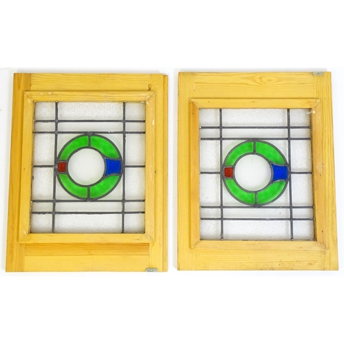 1261 - A pair of 20thC stained glass panels with green, red and blue roundel detail. Approx. 23 3/4